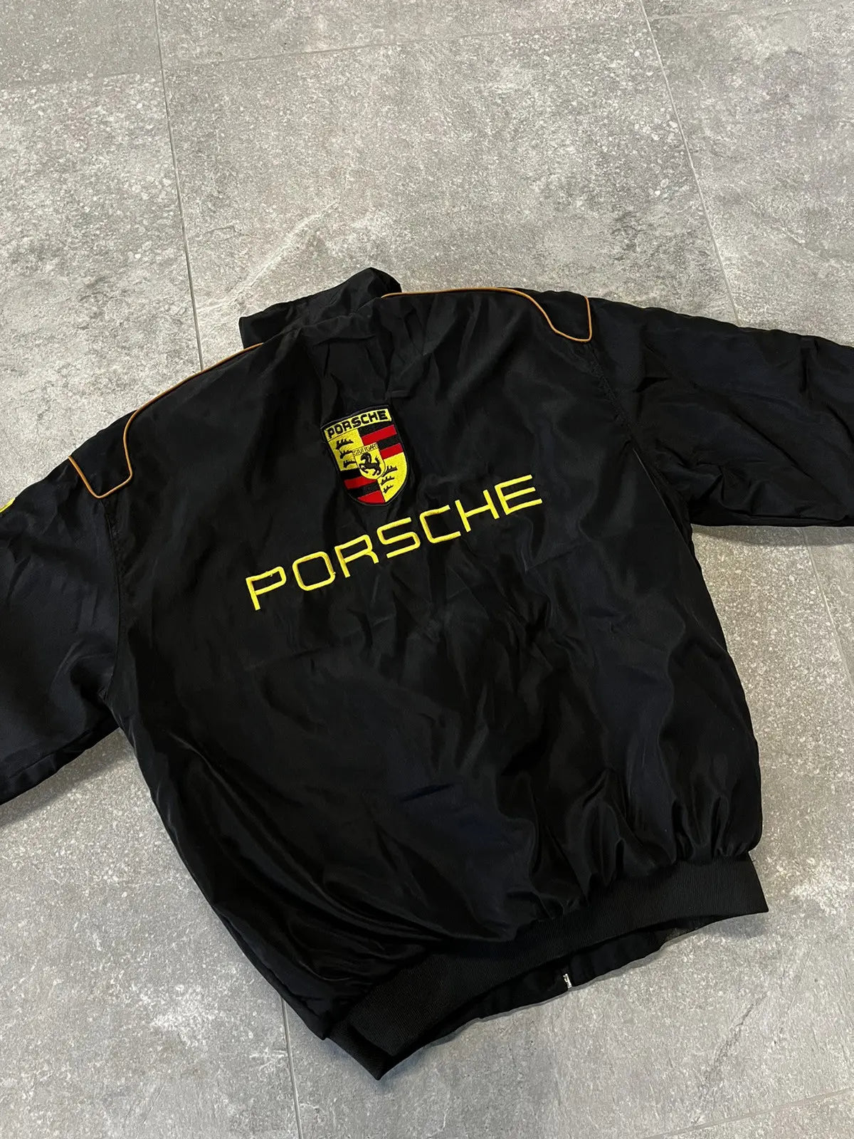 Porsche Racing Jacket Backside with yellow text and logos, featuring a Porsche Logo