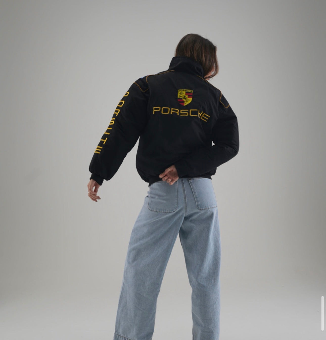 Porsche Racing Jacket front side with yellow text and logos, featuring a front zipper and pockets.