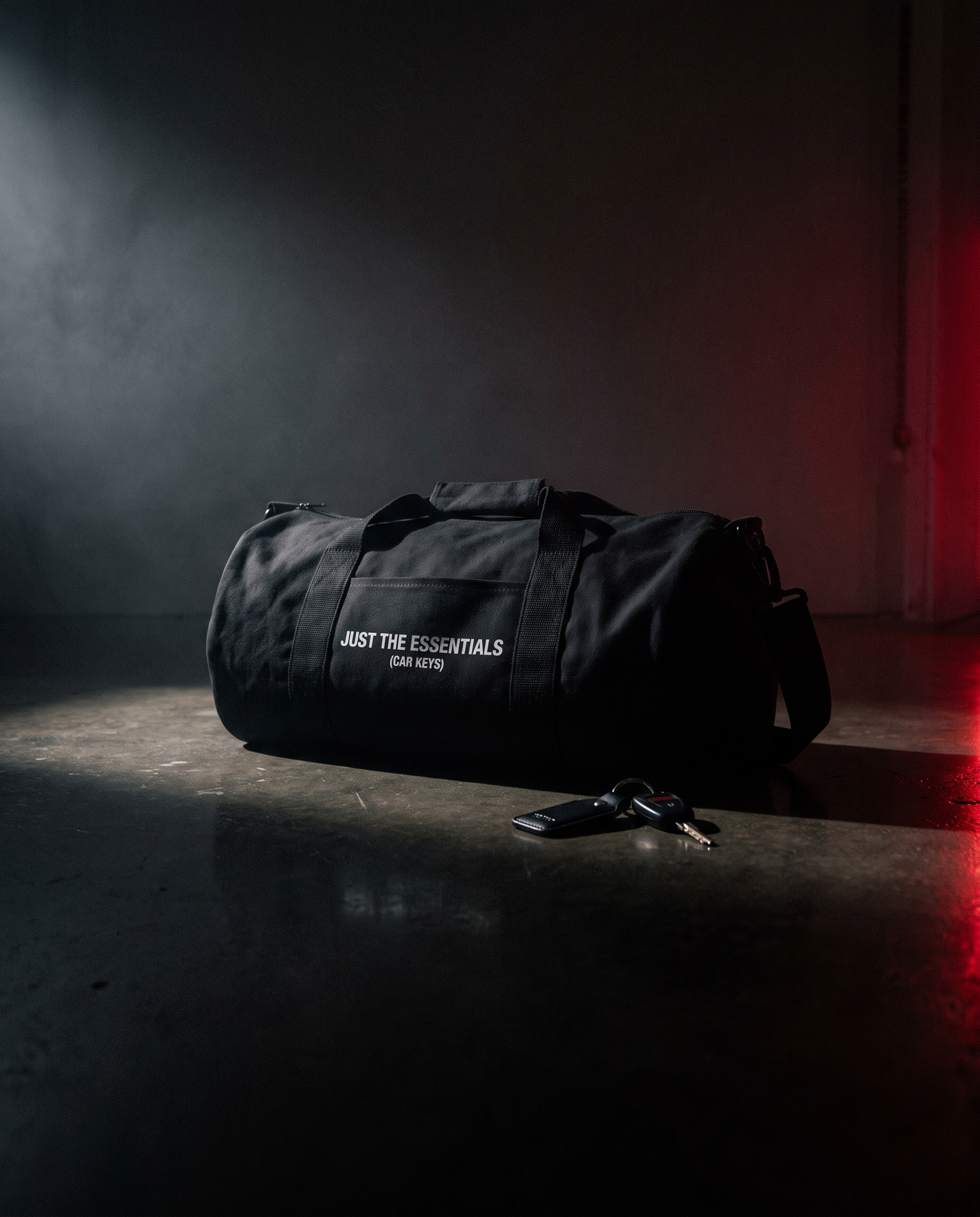 Just the Essentials duffle bag on dark garage floor with car keys