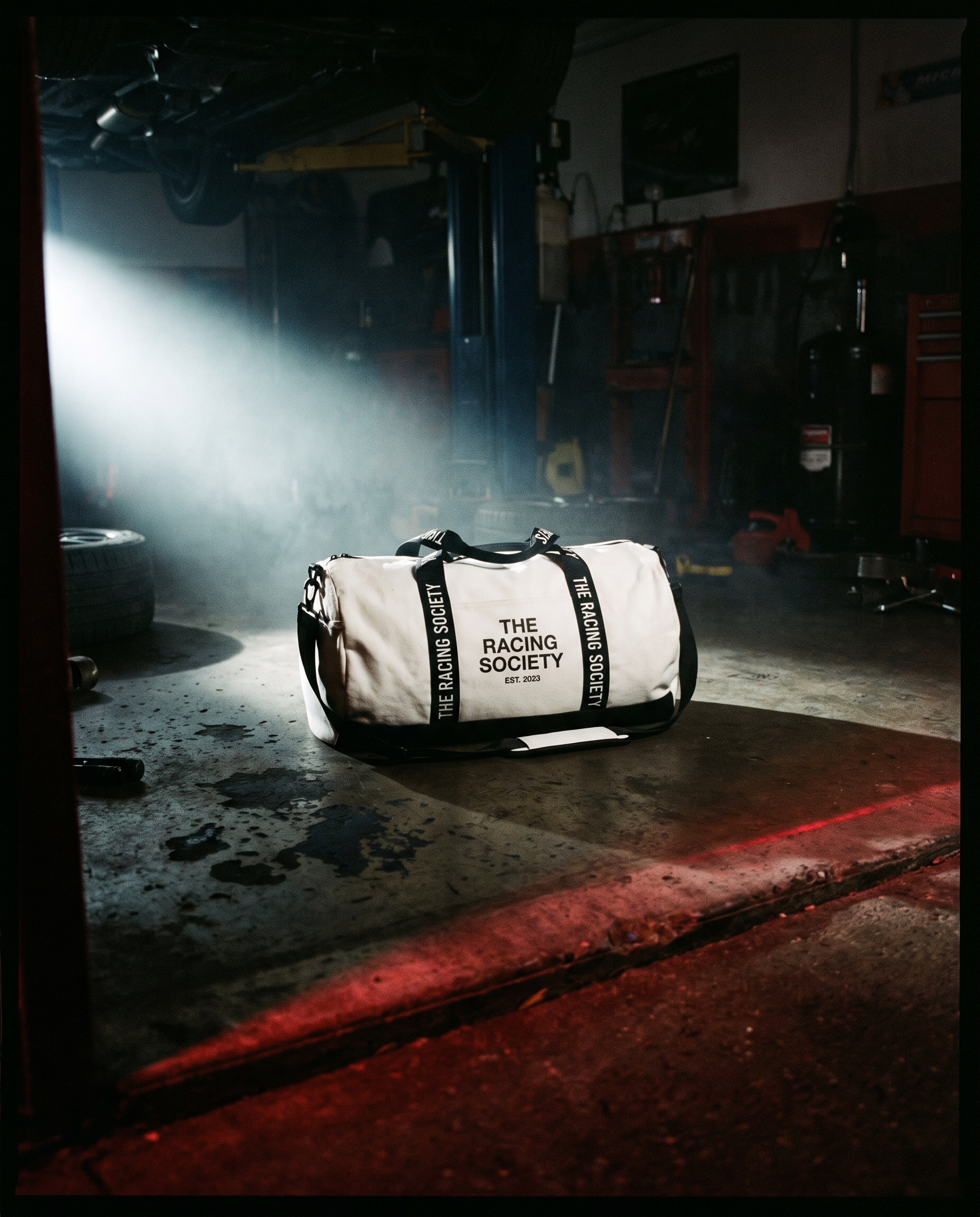 Wordmark duffle bag white in dark garage under spotlight