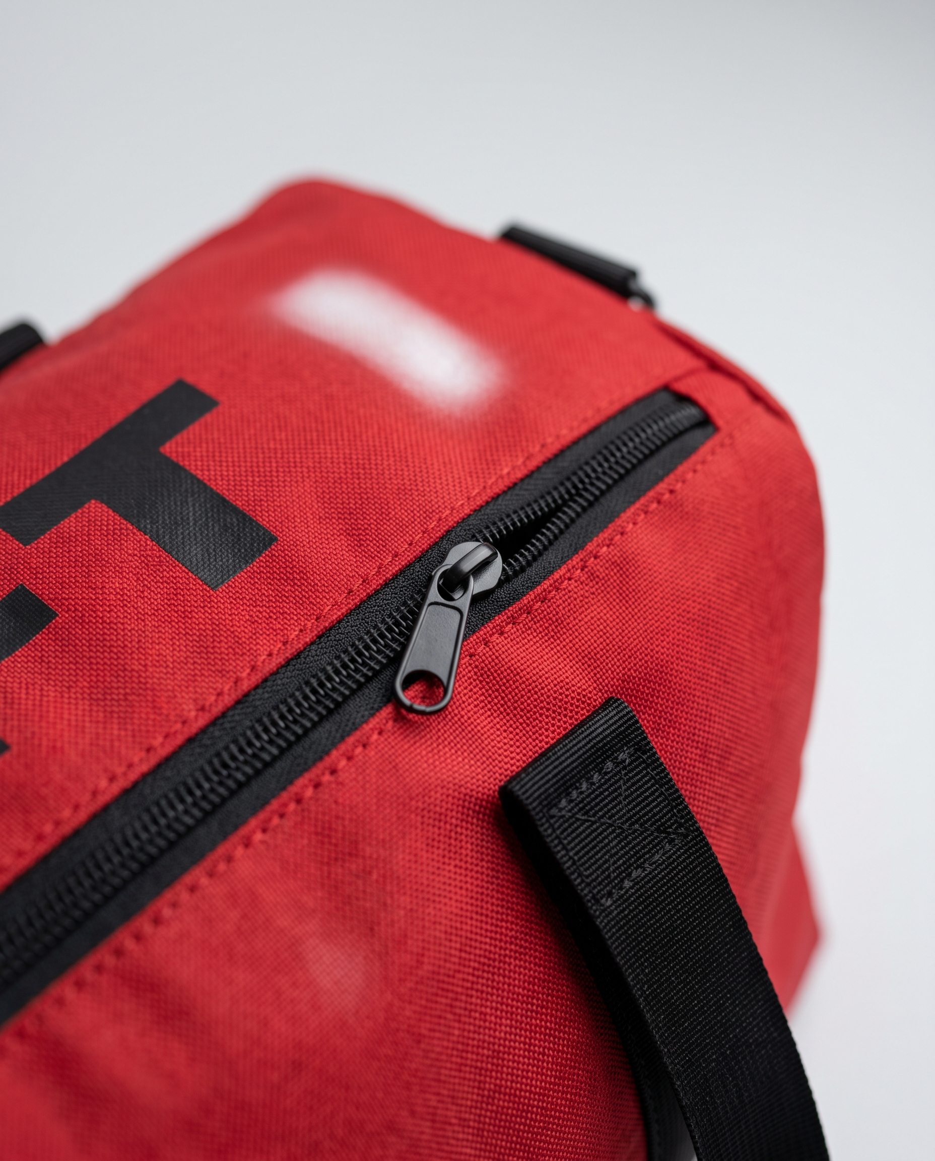 TRS Monogram duffle racing red — macro detail of zipper and letters